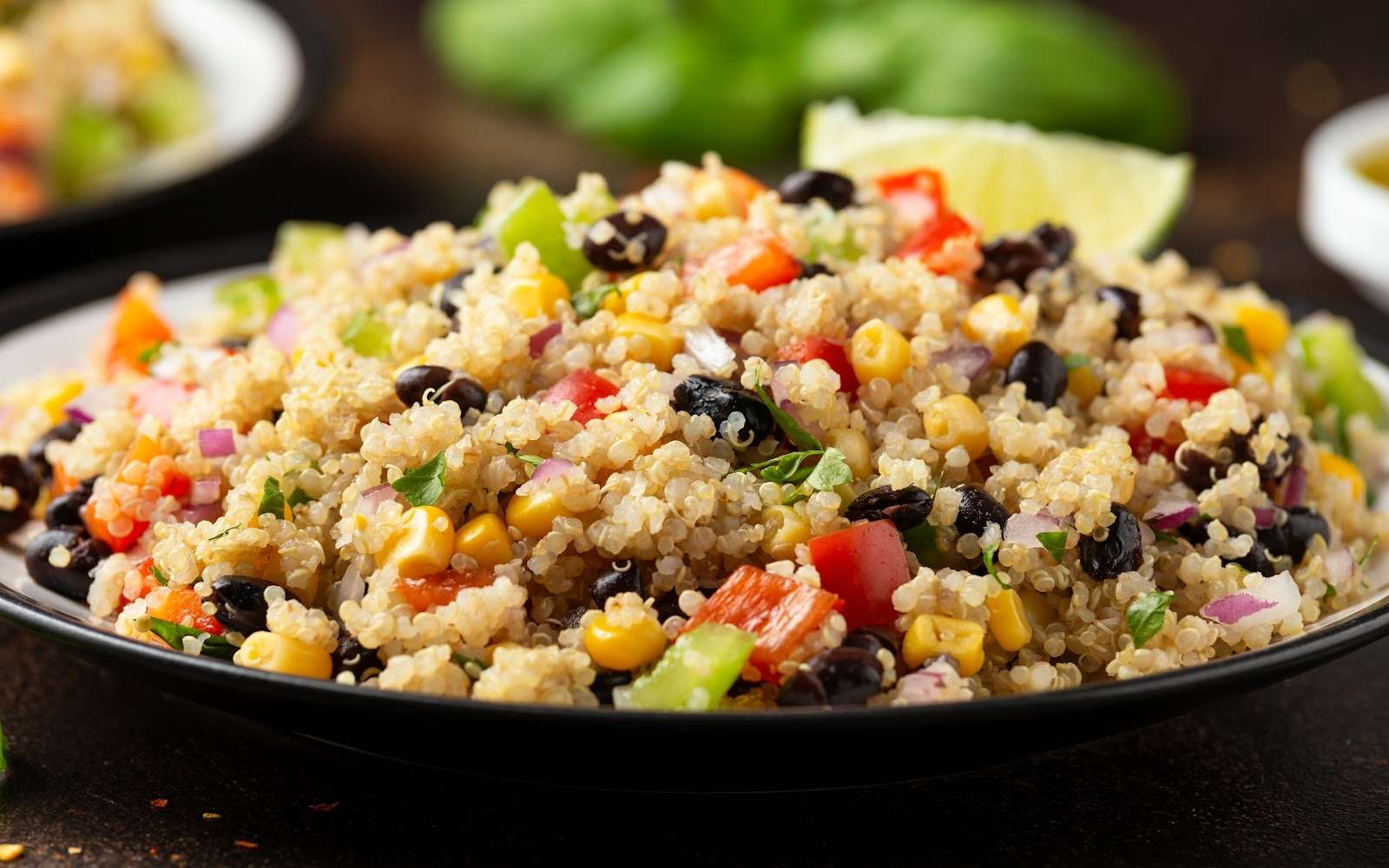 Vegan quinoa salad with black beans, corn, bell peppers, red onion, cilantro, and lime