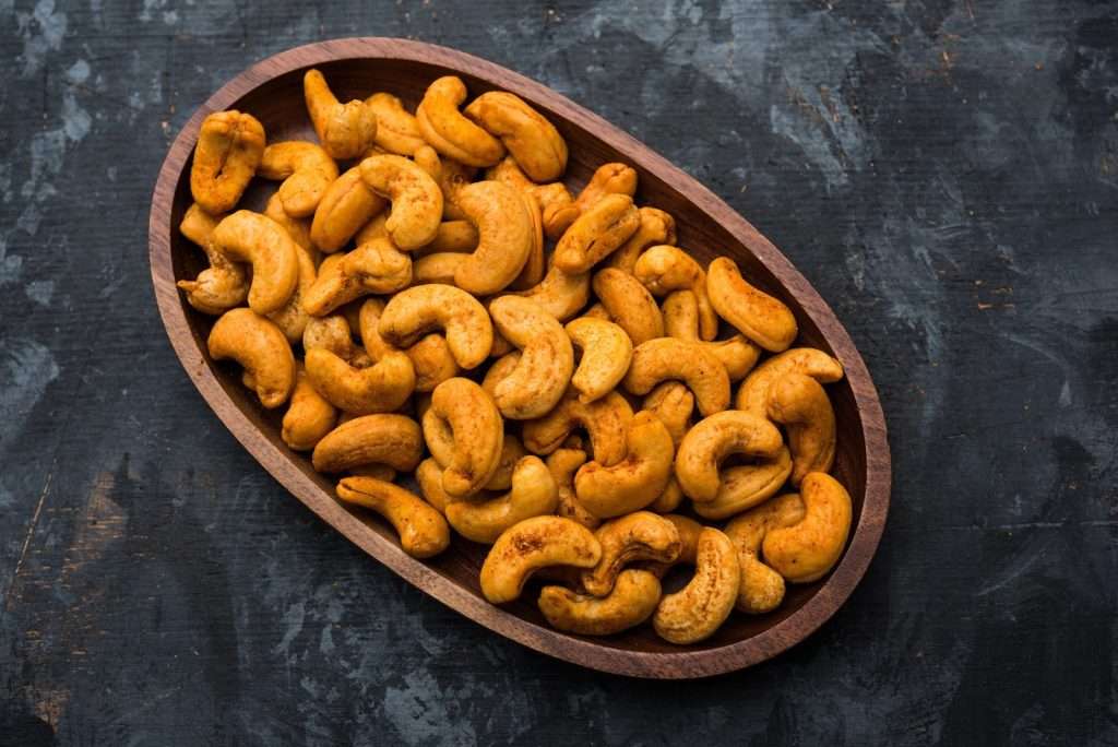 Chili-lime roasted cashews in a wooden bowl for a blood sugar-friendly vegan snack