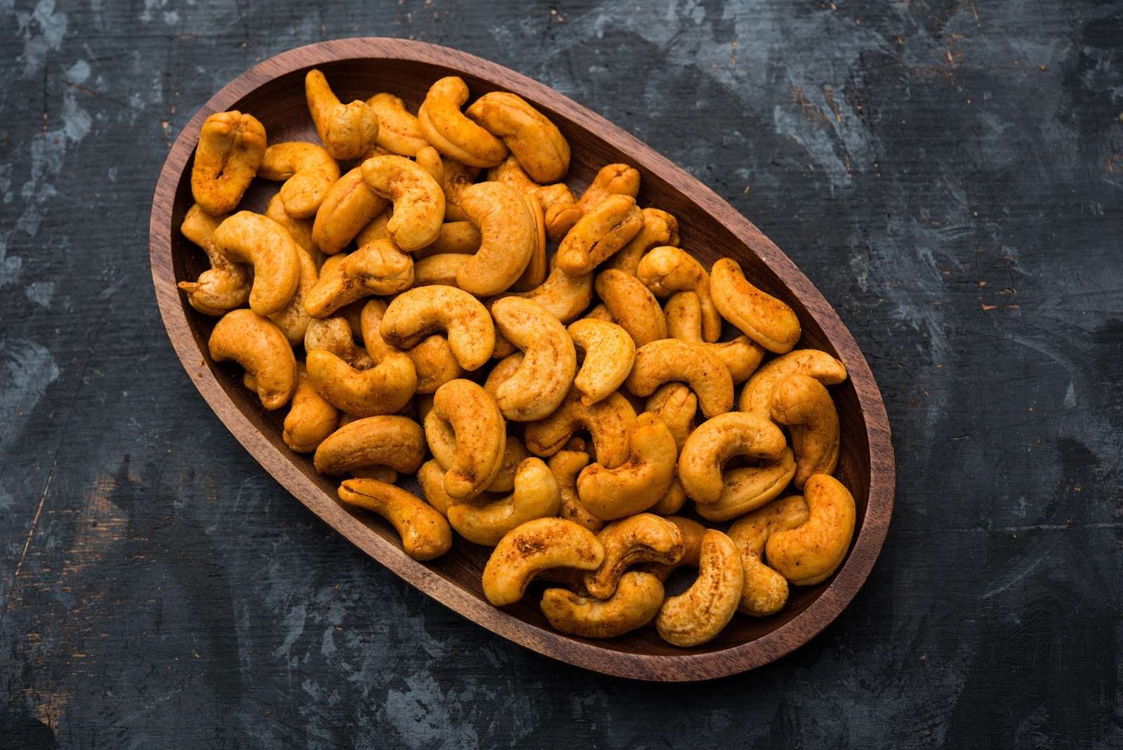 Chili-lime roasted cashews in a wooden bowl for a blood sugar-friendly vegan snack